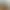 Hotelrezeption mit Holz- und Glastresen, zwei Lampen und einem Bildschirm, in einem hellen Raum mit großen Fenstern gelegen